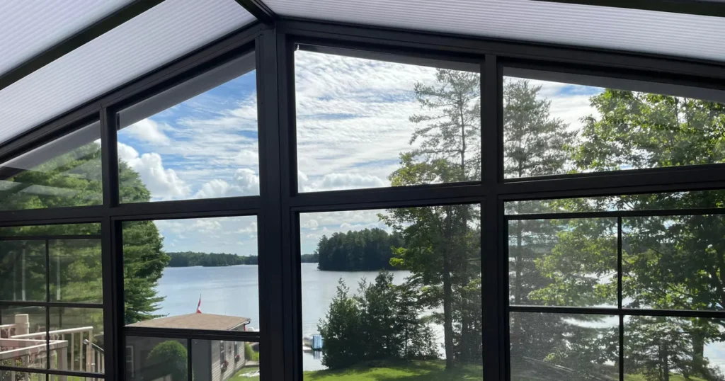 Open 4-track vinyl windows overlooking water from a bright sunroom