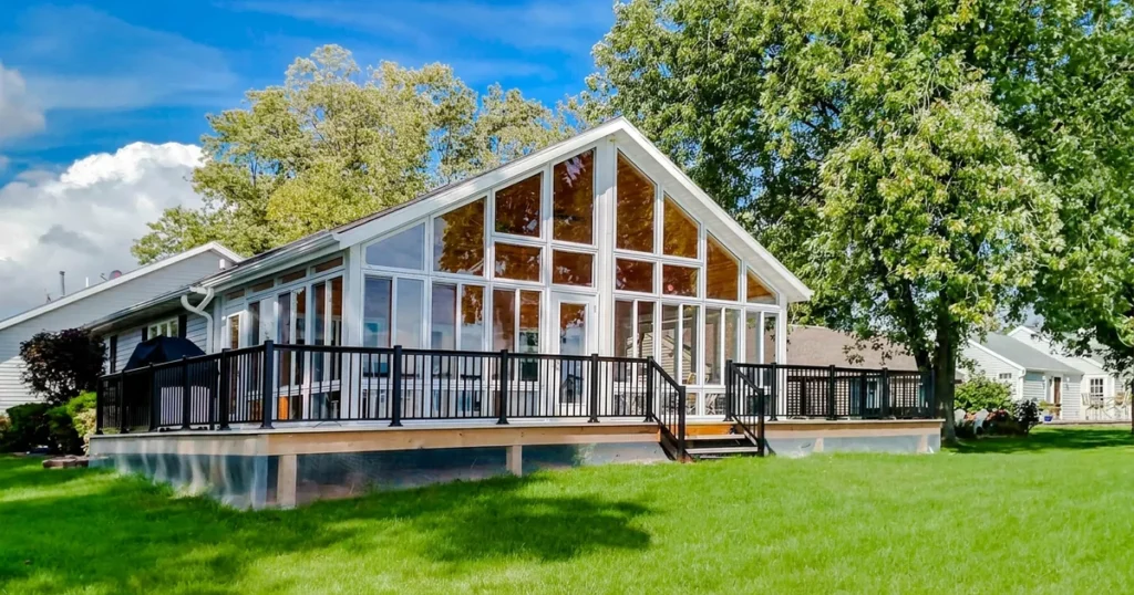 Insulated glass sunroom overlooking a green backyard in summer