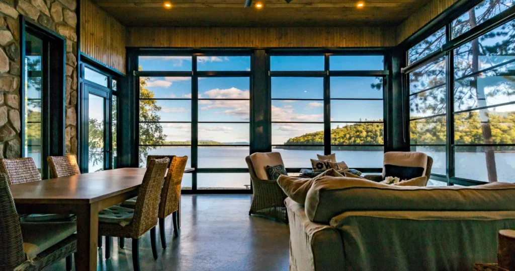 Waterfront porch enclosed with black four-track vinyl windows