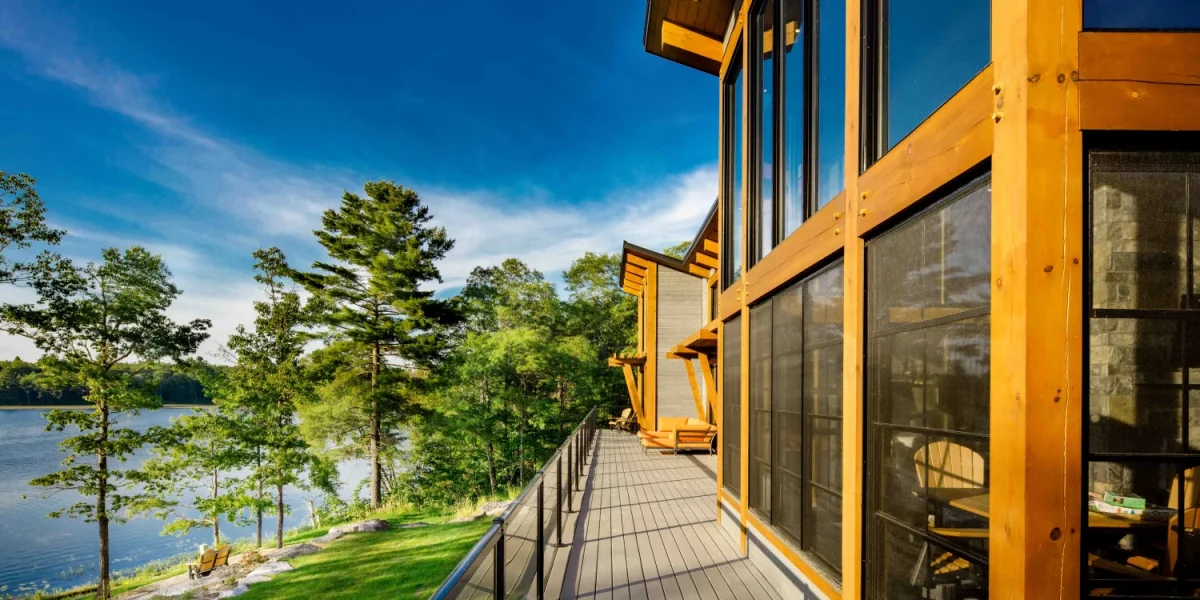Mesh-screened waterfront porch windows in warm late-day light
